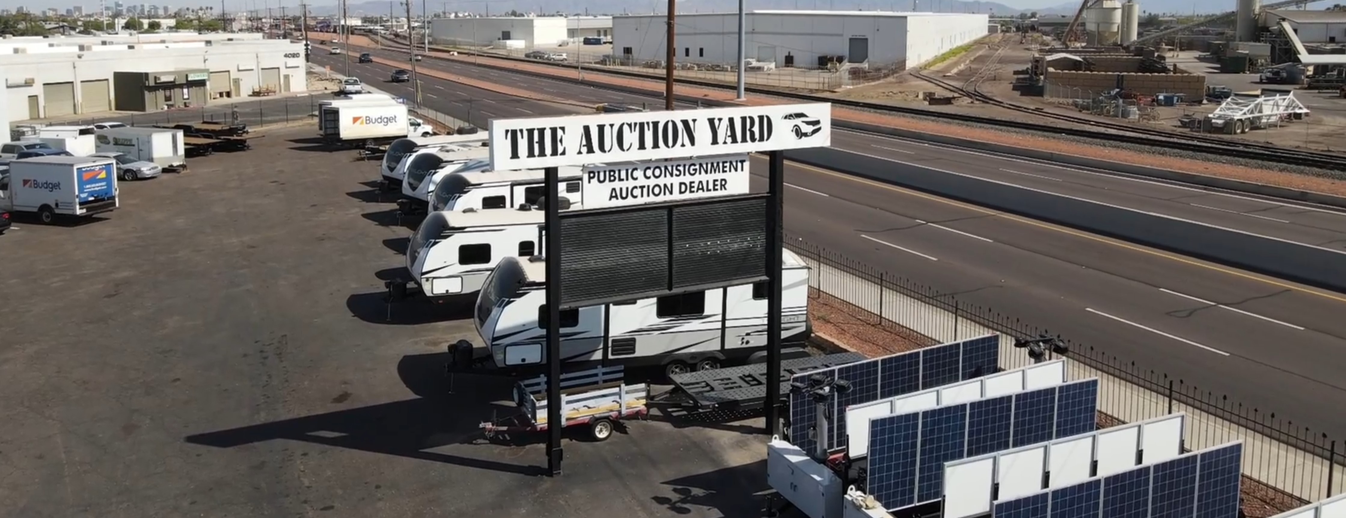The Auction Yard sign and vehicle auction lot in Peoria Arizona